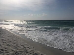 Image shows ocean waves coming up on the beach at Destin, Florida.